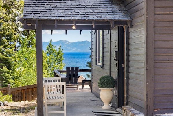 Ein Holzhaus mit überdachter Veranda, einem Tisch mit Stühlen und einem Blumentopf.