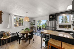 Eine moderne Küche mit Essbereich, großen Fenstern und Blick ins Freie.