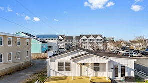 Un barrio residencial con varias casas, incluyendo una casita blanca con porche y garaje.