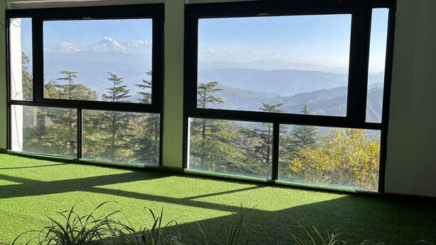Una habitación con amplios ventanales que ofrecen vistas a la montaña.