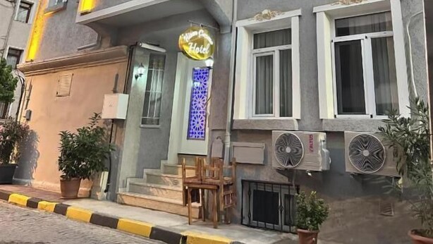 A multi-story hotel with a balcony, a neon sign, and outdoor seating. - Hisar Çeşme Hotel (Istanbul)