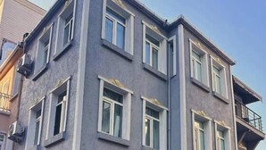 A multi-story building with a flat facade, multiple windows, and a balcony on the upper floor. - Hisar Çeşme Hotel (Istanbul)
