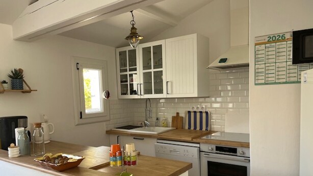 A kitchen with white cabinets, a wooden countertop, a sink, a stove, and a microwave. - House with pets allowed - 4 guests (Barbâtre)