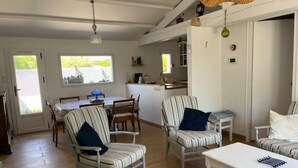 A spacious living area with a dining table, two striped armchairs, a sofa, and a coffee table. - House with pets allowed - 4 guests (Barbâtre)