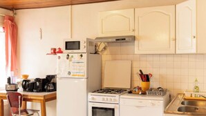 Una cocina equipada con estufa, microondas, refrigerador y pileta.