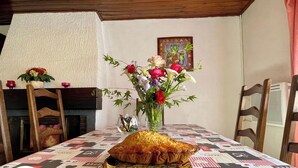 Una mesa de comedor con un centro de mesa floral, un pastel y un pequeño adorno.