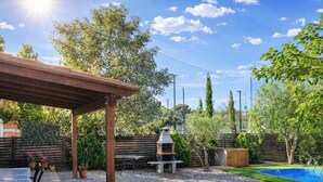 A covered patio area with a grill, a pool, and a table with chairs. - Charming house near beach - Costa Brava (Palamós)