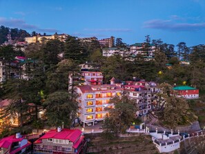 A multi-story hotel with balconies, surrounded by trees and other buildings. - PACK Shimla (Shimla)