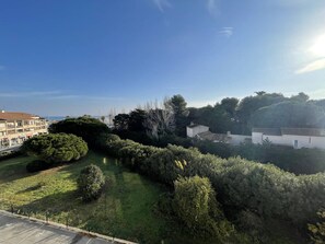 Ein Wohngebiet mit blauem Himmel, einem grünen Rasen und einem weißen Gebäude mit Ziegeldeckung.