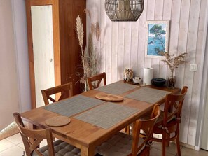 Ein Essbereich mit einem Holztisch, gewebten Tischsets und Stühlen.