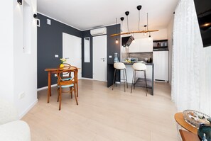 Een moderne keuken met een eetgedeelte, een inbouwoven en een witte koelkast.