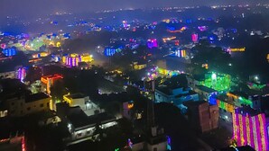 Eine beleuchtete Stadtlandschaft bei Nacht mit glänzenden Gebäuden und Straßen.