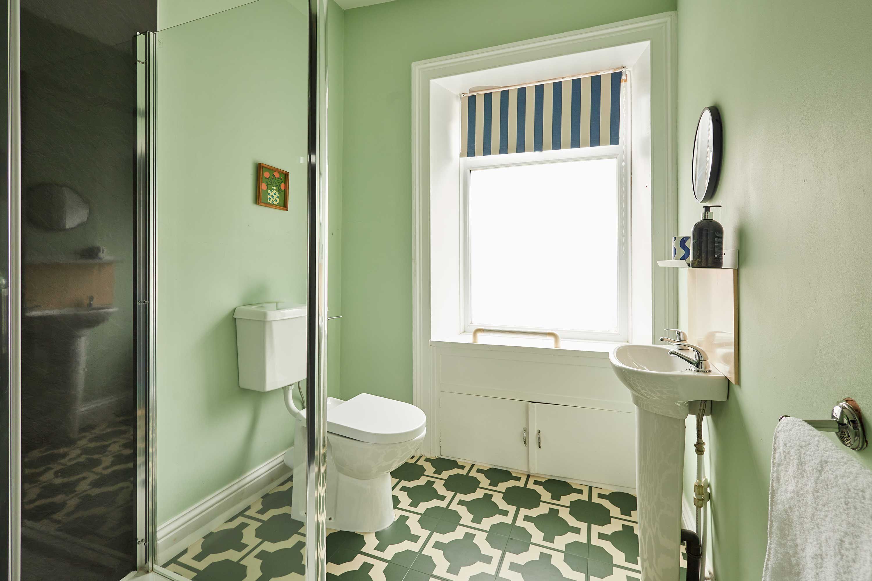 Une salle de bain avec des toilettes, un lavabo et une douche.