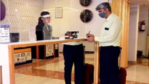 A reception desk with a glass partition, a clock on the wall, and a fire extinguisher mounted on the wall. - Hotel Star (Shivpuri)