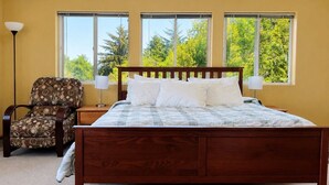 A bedroom with a wooden bed, a chair, and a nightstand.