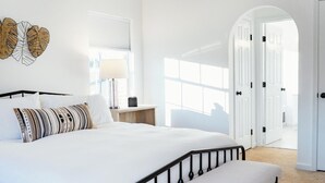 A modern bedroom with a large bed, a bedside table, a lamp, and a decorative wall piece. - Spacious Summer Oaisis 4-bedroom house with AC in Kerhonkson (Kerhonkson)