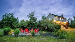 A house with a stone patio, red chairs, and a fire pit. - Spacious Summer Oaisis 4-bedroom house with AC in Kerhonkson (Kerhonkson)