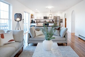 Ein modernes Wohnzimmer mit einer Couch, einem Couchtisch und einer Blumenvase.