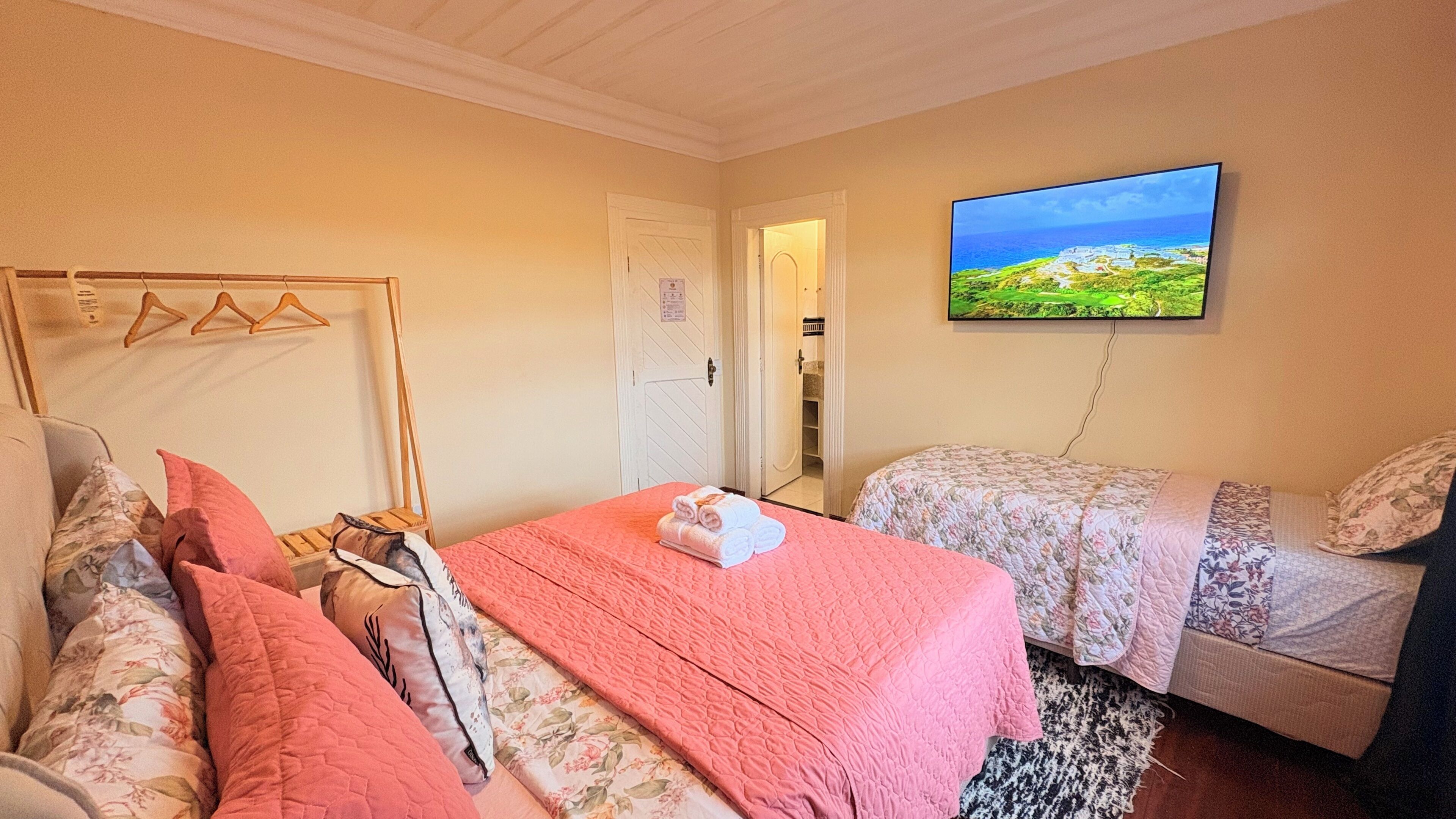 A hotel room with a bed, two bedside tables, a television, and a view of a landscape.