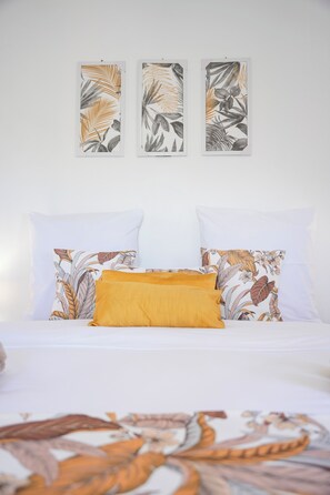 A bed with white bedding and pillows, a mustard-colored throw, and three framed botanical prints on the wall. - Le Charme d'Antan, for 6 people, A house, A memory, An emotion (Cilaos)