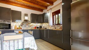 Una cocina con una mesa de comedor, electrodomésticos de acero inoxidable y un salpicadero de azulejos.