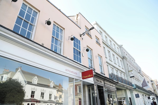 A building with a 'Chancellors' sign, large windows, and a reflection of another building. - Bright & Modern 2 Bed Apartment in the heart of Windsor - opposite the Castle (Windsor)