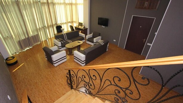 A modern living room with a sofa set, a coffee table, and a TV mounted on the wall.