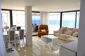 A modern living room with a sofa, armchairs, a coffee table, and a dining area with chairs and a table. - Paradise view - Funchal (Funchal)