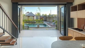 Un interno moderno con vista su una piscina esterna, un gazebo e un patio.
