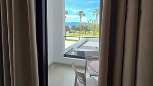 A room with a large window, a chair, and a table. - Suites By Jordan's Hotel (Vlore)
