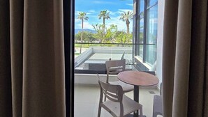 A modern room with a large window, a table, and two chairs. - Suites By Jordan's Hotel (Vlore)