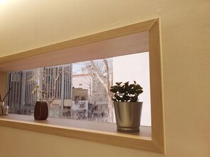A window with a view of a building and a potted plant on the sill. - STAY Ann Iksun (Seoul)