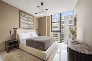 Ein modernes Schlafzimmer mit einem großen Bett, einem Nachttisch, einer Wandlampe, einer Stehlampe, einem großen Fenster und Blick auf die Stadtlandschaft.