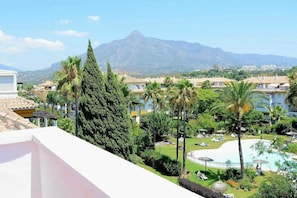 Ein Resort mit Pool, Palmen und Bergen im Hintergrund.