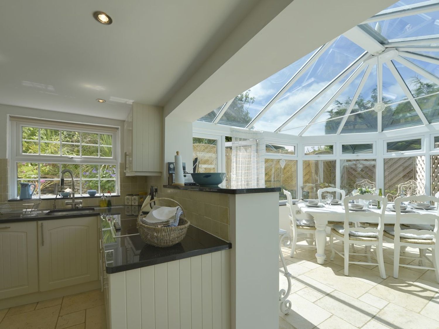 A kitchen with a large window and a conservatory.