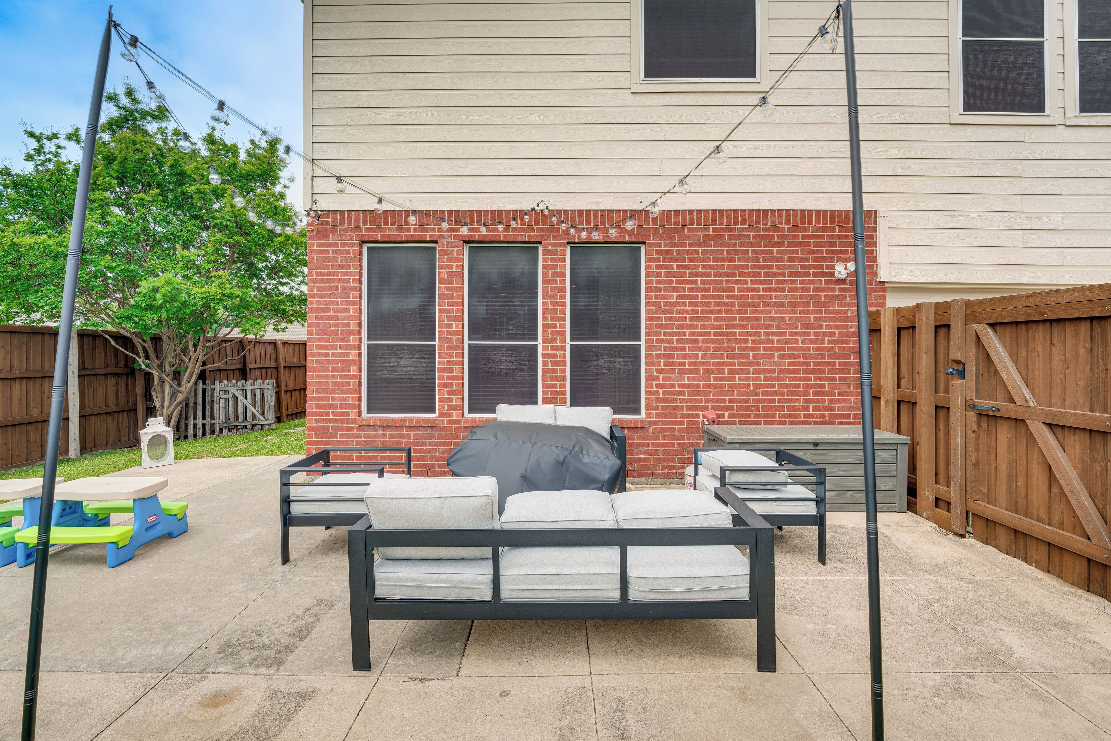 A backyard with a black metal bed frame, a picnic table, and a wooden fence.