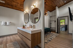 A modern bathroom with a wooden vanity, two large mirrors, and a white sink. - Summit Splendor | Steps to The Trillium, Indoor Pool, Playground, Views! (Sevierville)