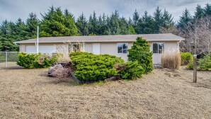 A single-story house with a garage, surrounded by a gravel driveway and various shrubs. - Ocean City Home w/ Fenced Yard: 1 Mi to Beach! (Ocean Shores)