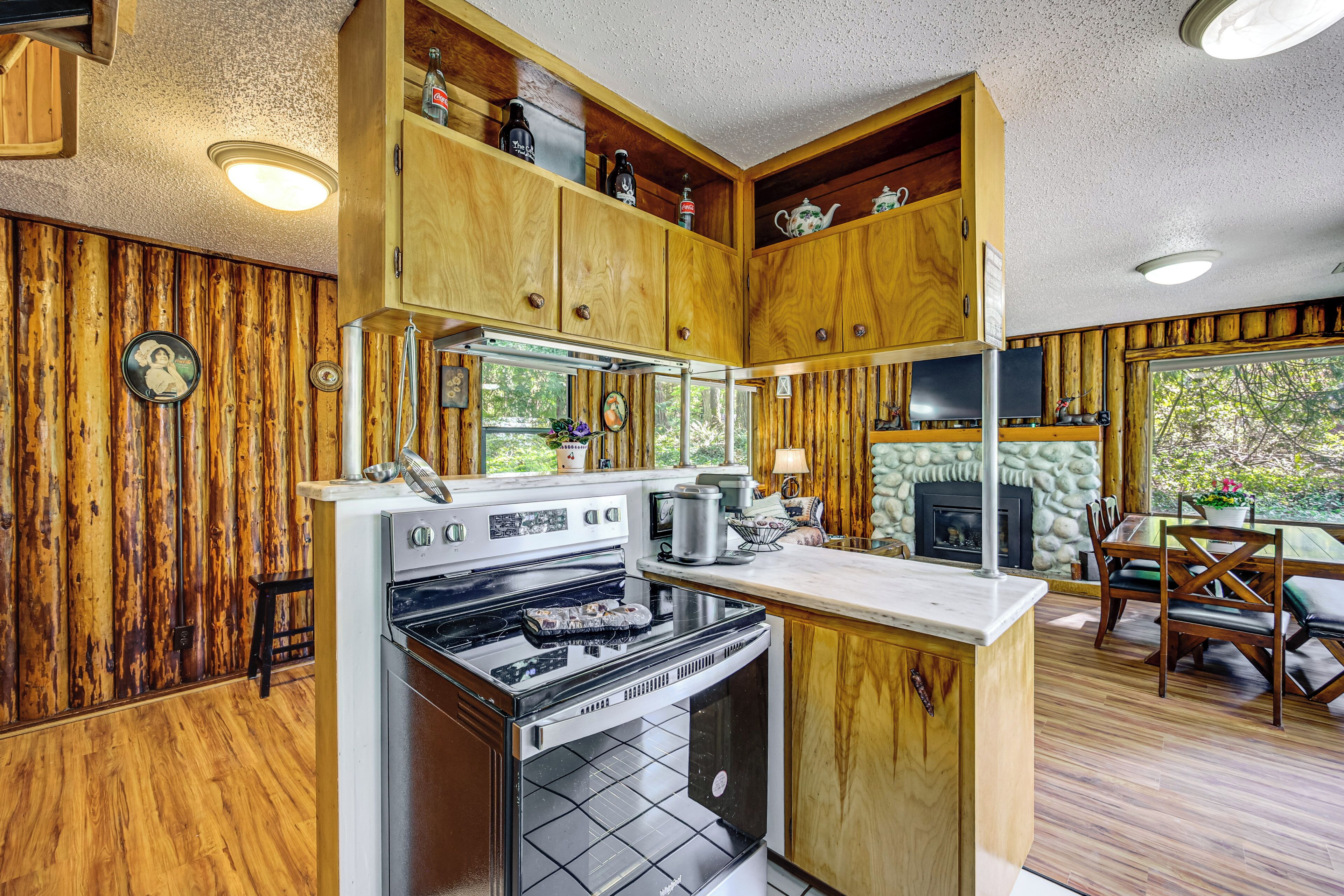 A kitchen with wooden cabinets, a stove, and a dining area with a table and chairs.