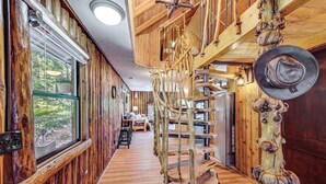 Un interior de fusta amb una escala espiraltra, grans finestres i decoració rústica.