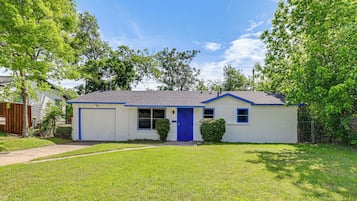 A single-story house with a blue front door, a garage, and a small front yard.