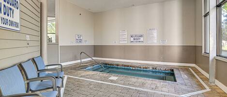 A pool area with a lifeguard duty sign, a shallow water warning sign, and a no lifeguard on duty sign.