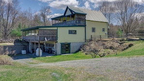 Ein zweistöckiges Haus mit Balkon, Garage und umzäunter Garten.