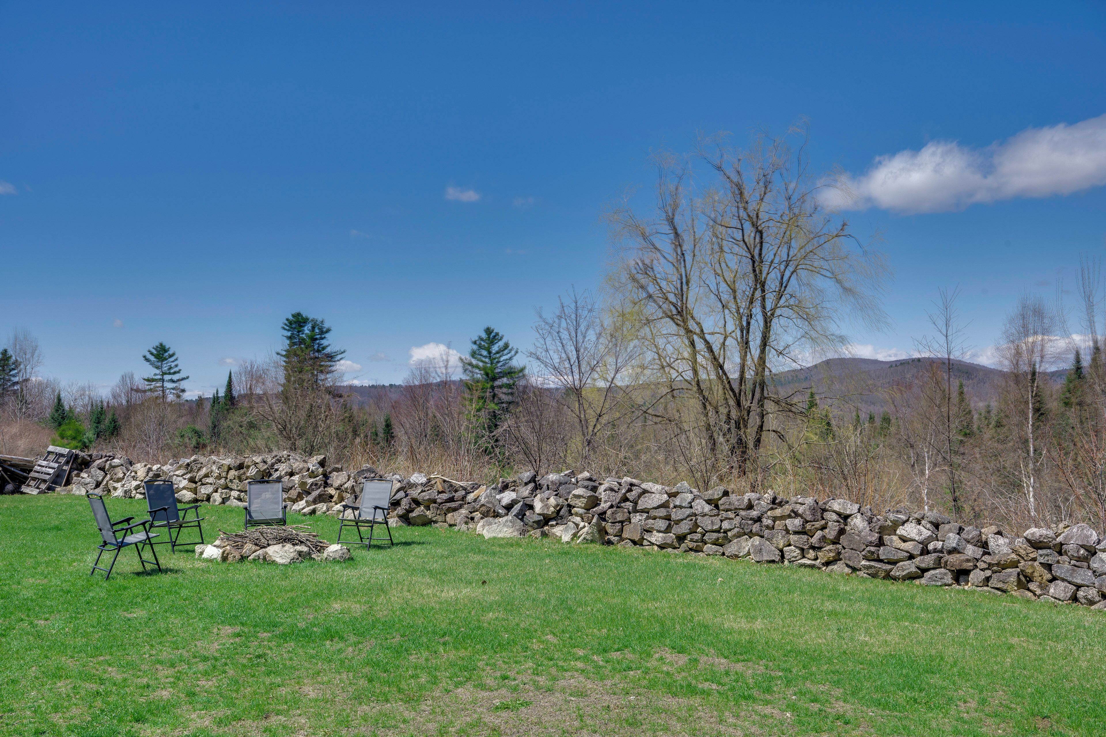 A stone wall, a grassy field, and a clear blue sky.