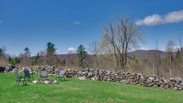 A stone wall, a grassy field, and a clear blue sky.