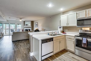 A modern kitchen with white cabinetry, a dishwasher, an oven, and a microwave. - Lake & Boat Slip Access! Family Gem in Osage Beach (Osage Beach)