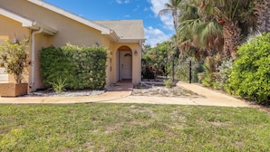 A residential house with a front entrance, a covered porch, and a well-maintained lawn. - Steps to Sand! Pet-friendly Home in Fort Pierce (Fort Pierce)