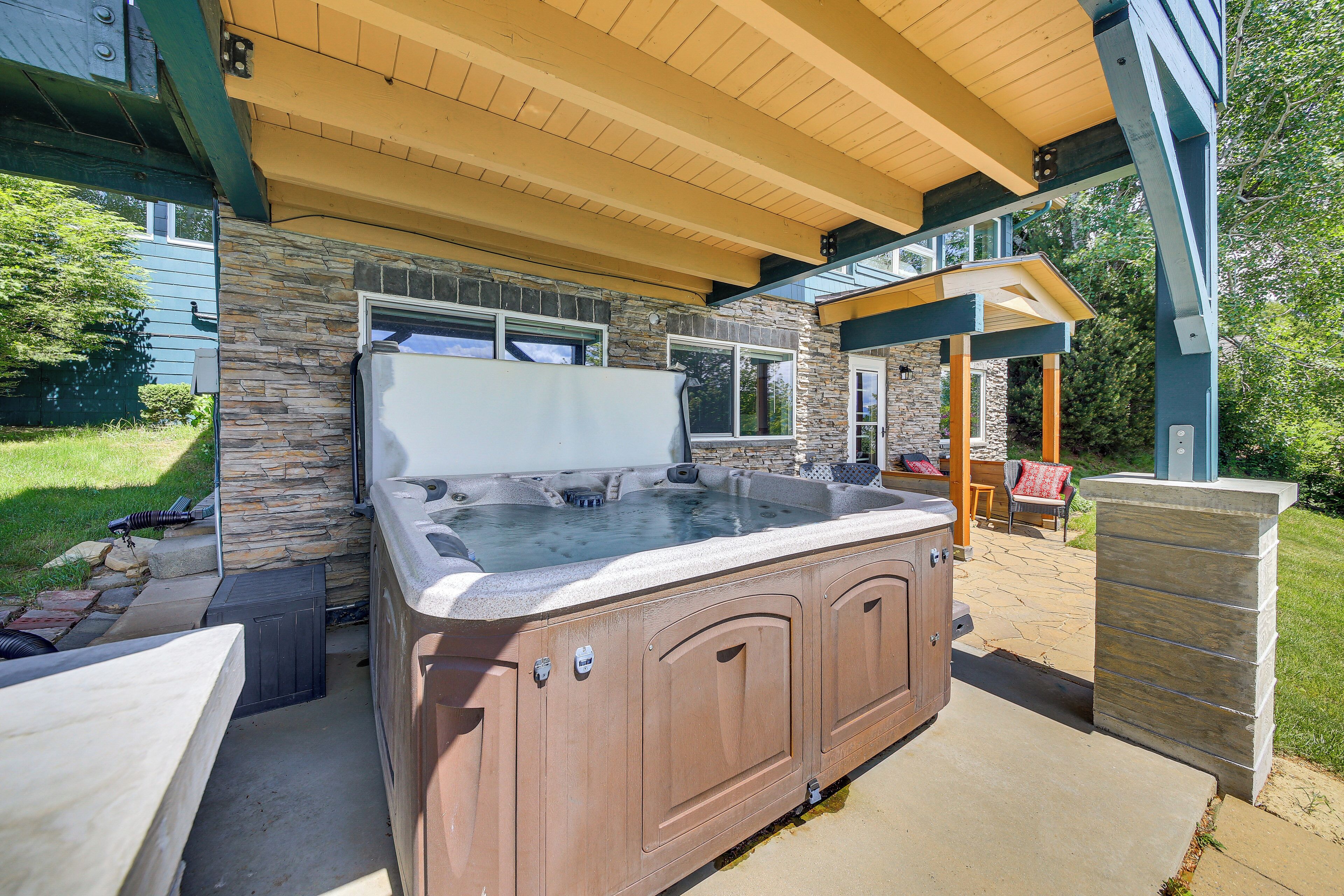 A hot tub with stone walls and a wooden deck.