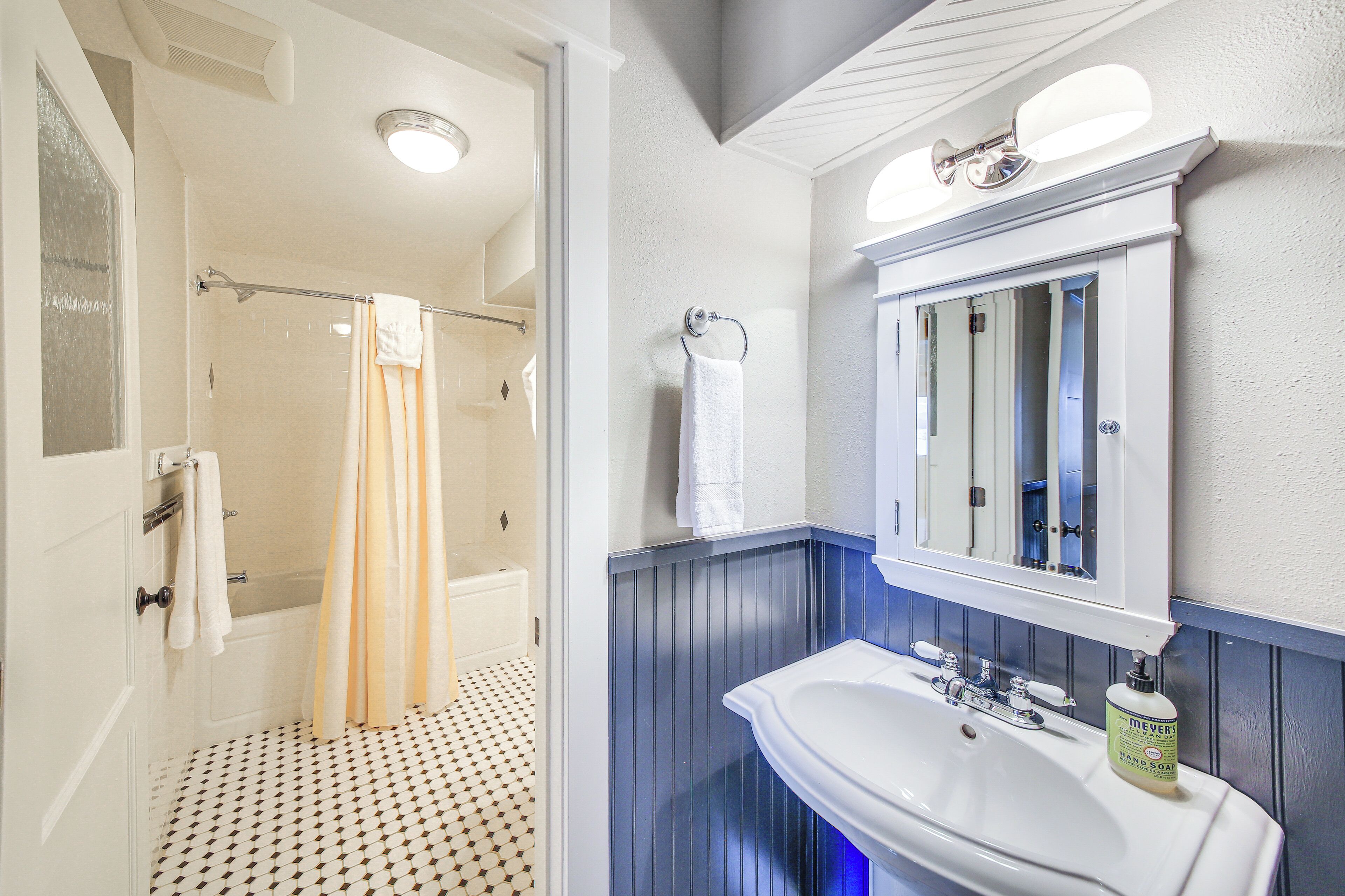 A bathroom with a bathtub, a sink, and a mirror.