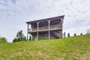 A two-story stone building with a balcony and stairs.